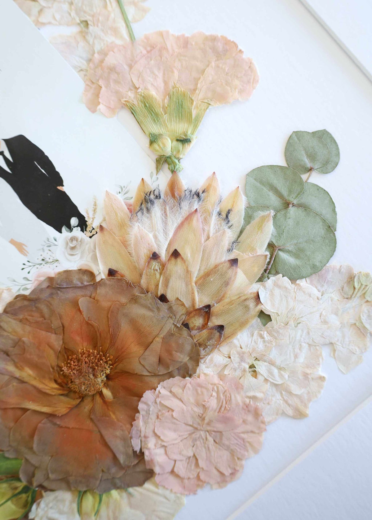 Framed pressed bridal flowers with wedding vows, invitation, and photo display