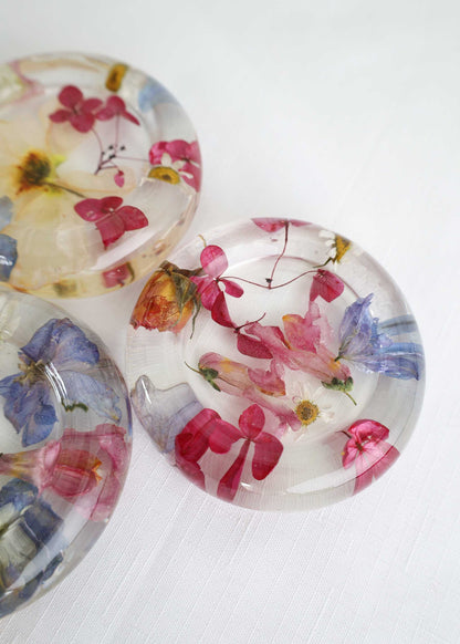 Resin Trinket Dish, clear round resin with embedded pink, blue and yellow dried flowers and delicate botanical details.