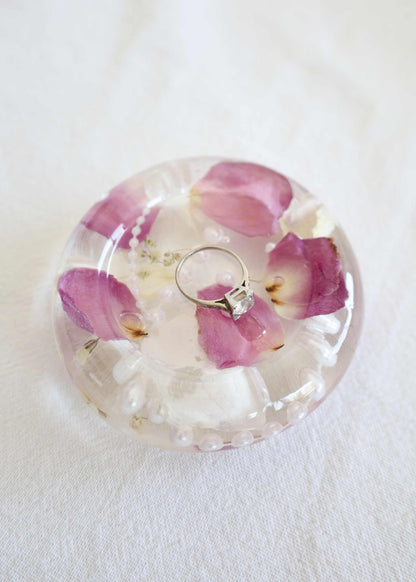 Resin Trinket Dish made of clear resin, with preserved pink flower petals and small cream blooms embedded inside.