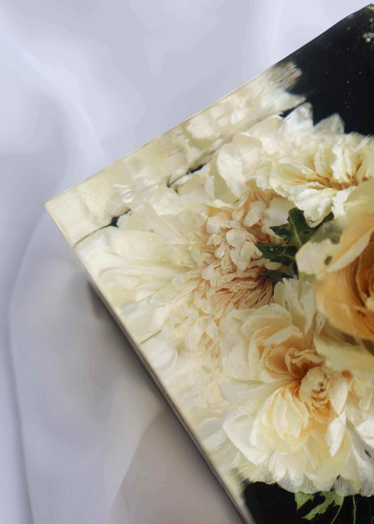 Set of Resin Display resin bookend with preserved cream and pale peach flowers against a glossy black background